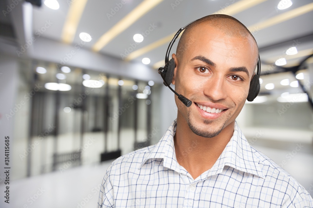 Smiling handsome businessman wearing headset looking at camera