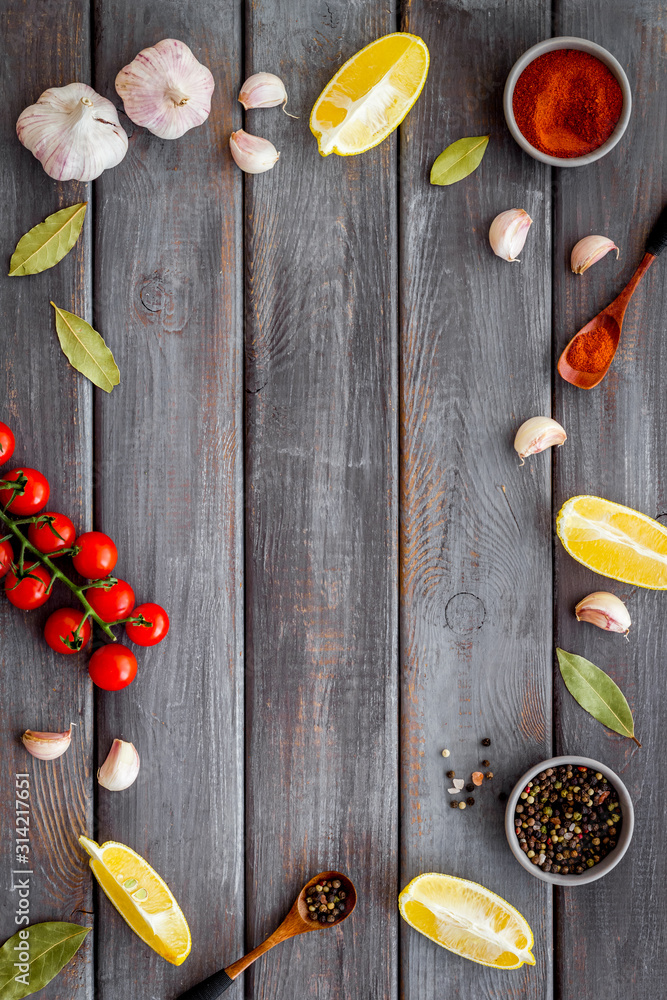 Kitchen frame with spices and food - pepper, garlic, tomatoes - on dark wooden background top-down f