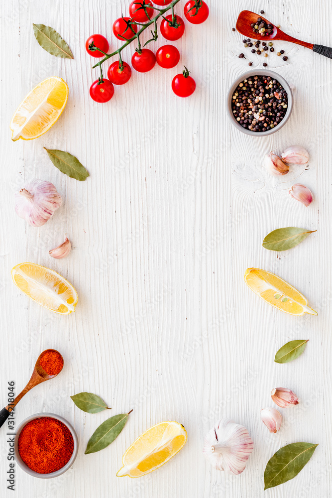 Kitchen frame with spices and food - pepper, garlic, cherry tomatoes - on white background top-down 