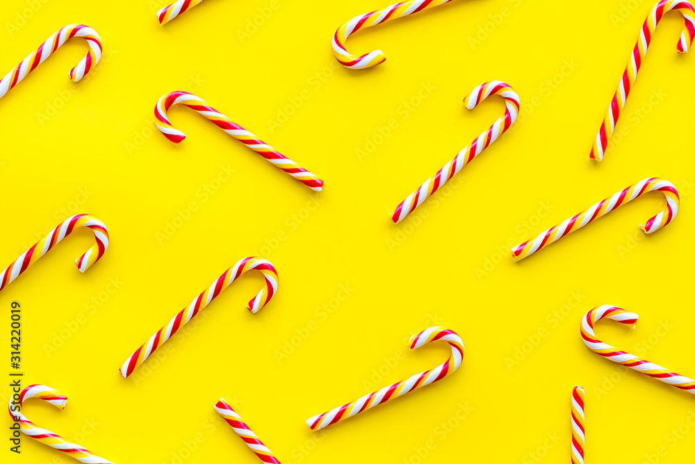 Christmas candy cane pattern on yellow background top-down