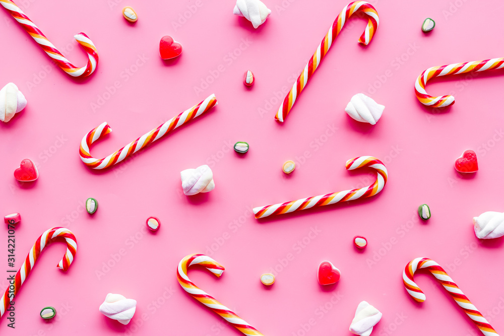 Christmas candies background on pink desk top-down pattern