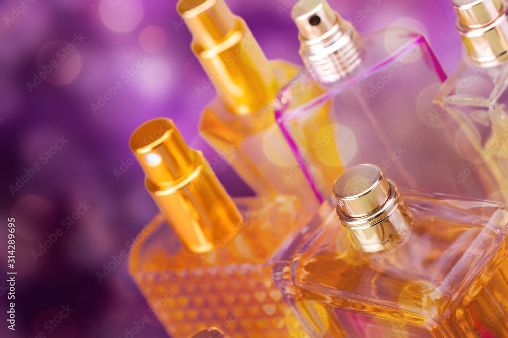 Aromatic Perfume bottles on wooden table on blurred background