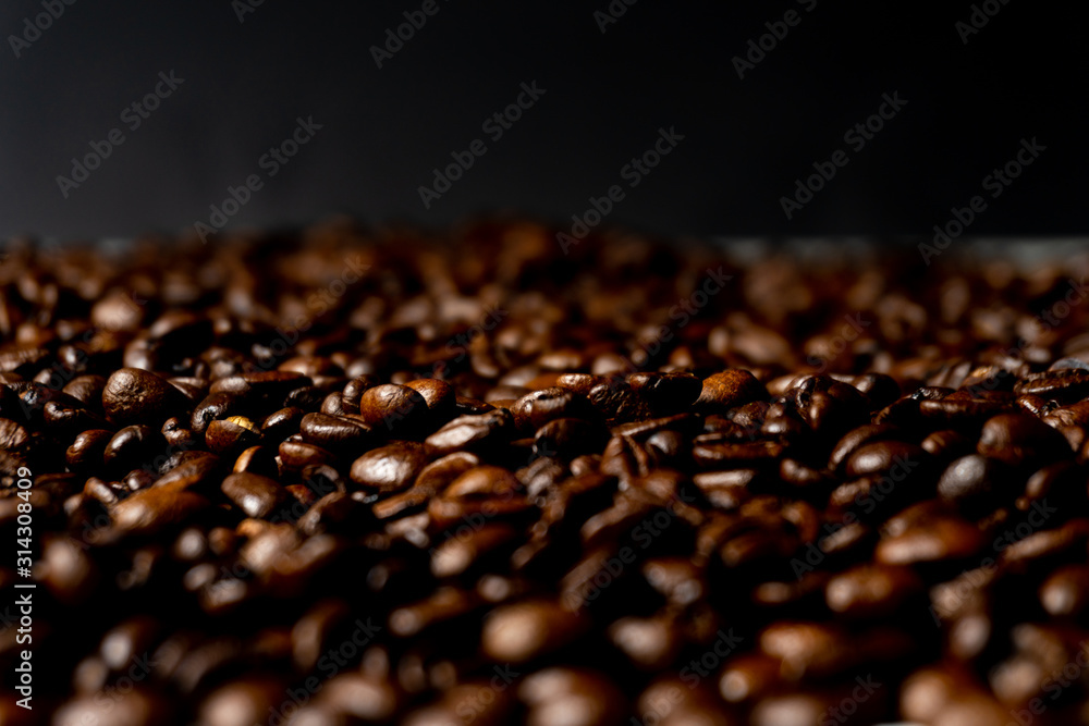 Close up of fresh roasted brown coffee beans - angled view with copy space