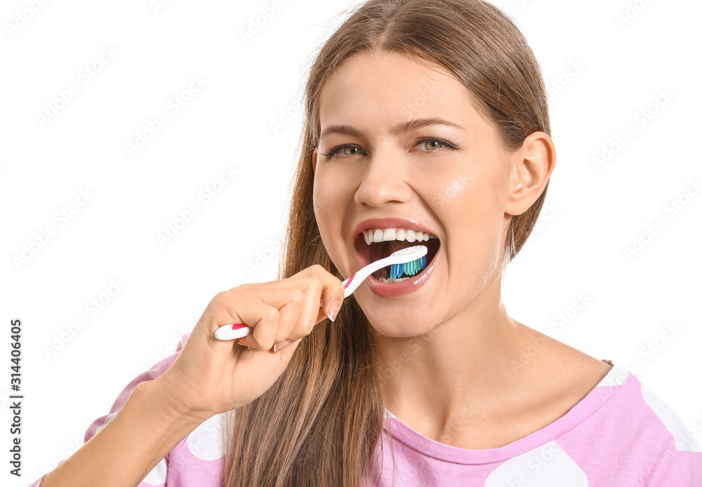 Young woman brushing teeth on white background