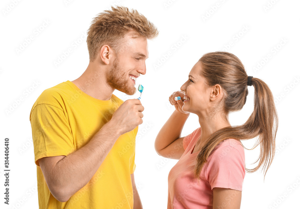 Young couple brushing teeth on white background