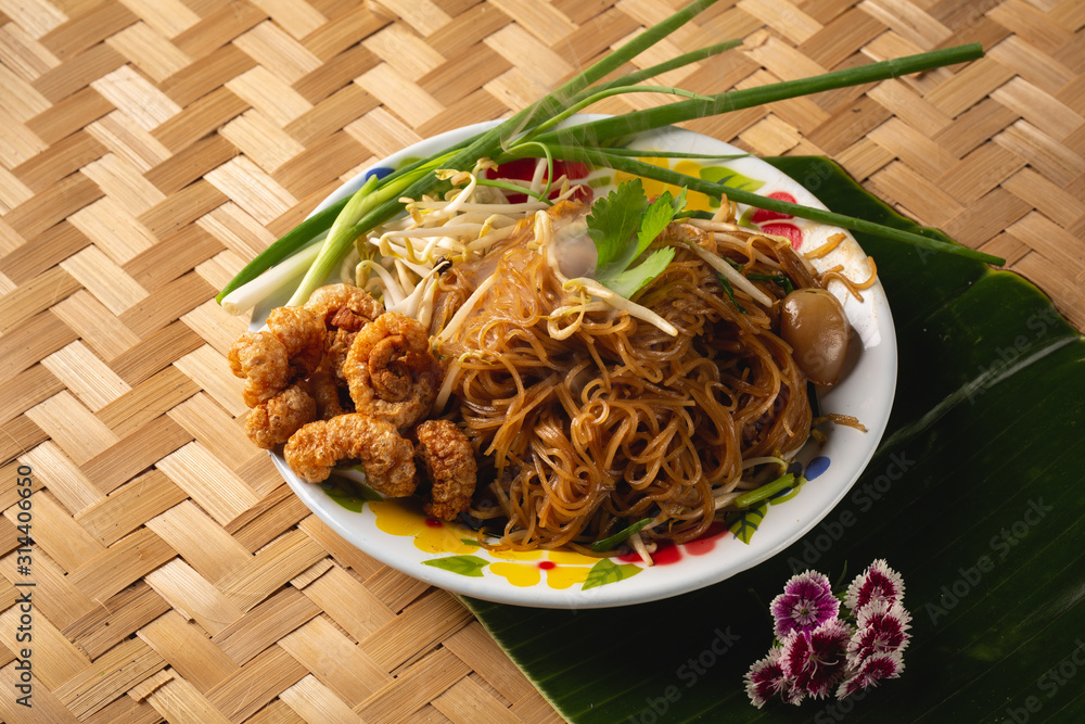 Asian rice noodles with Crispy pork and vegetables close-up on the table. top view of a horizontal