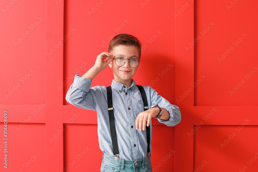 Cute fashionable boy on color background