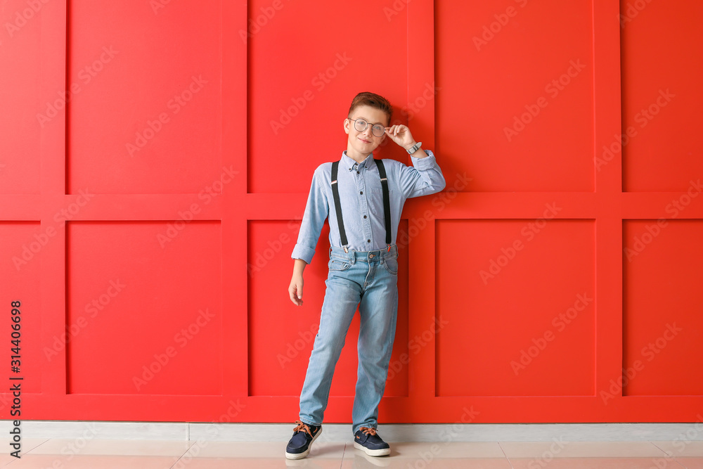 Cute fashionable boy on color background