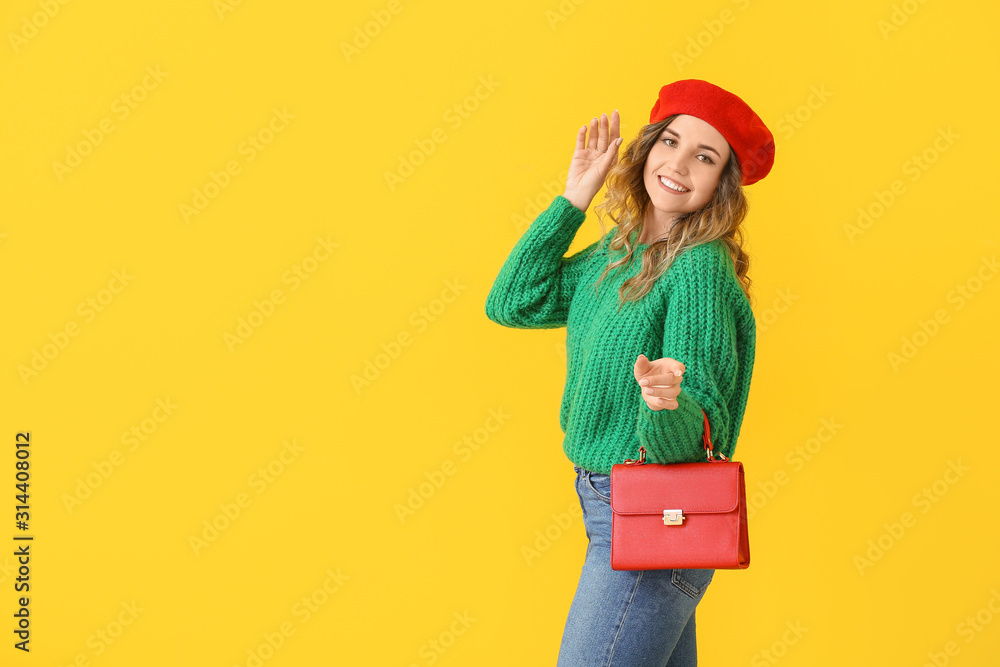 Beautiful young woman in warm sweater on color background