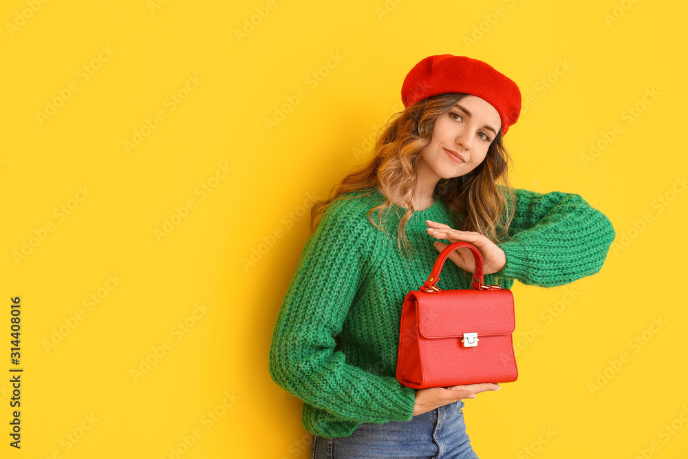 Beautiful young woman in warm sweater on color background