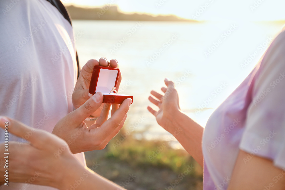 一个年轻人在河边向他心爱的人求婚，特写