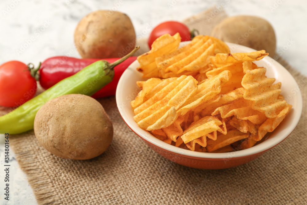 Plate with tasty potato chips on table