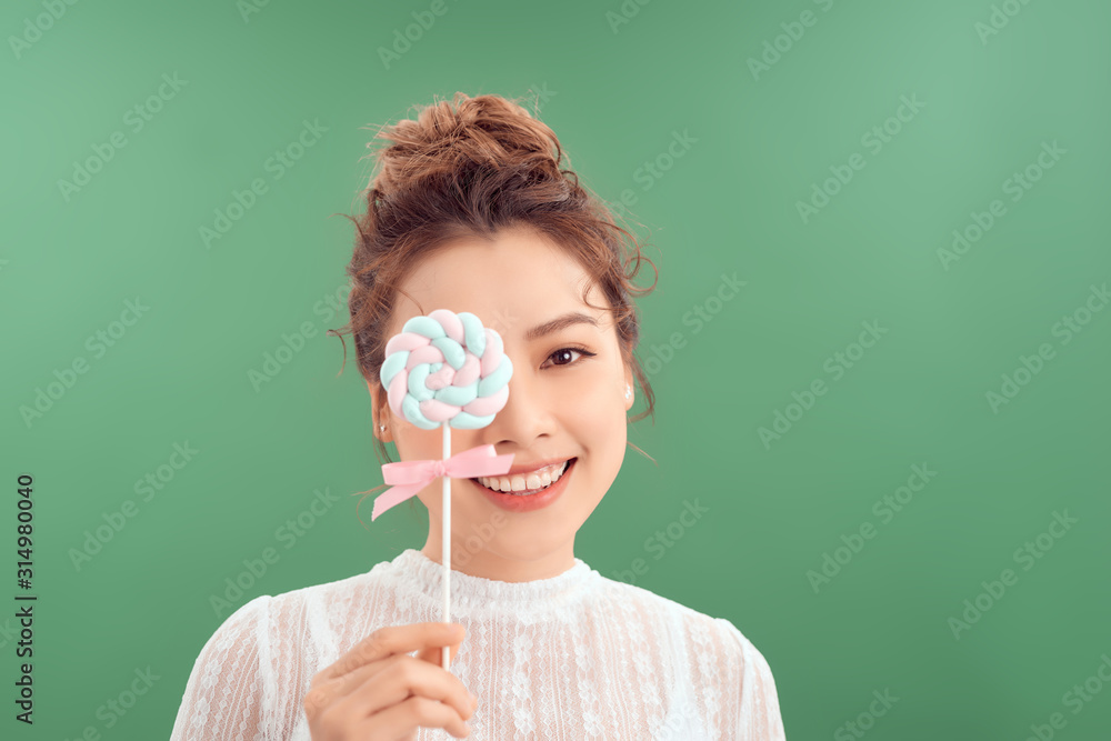 Asian girl with big candy on a stick, with a lollipop in hand