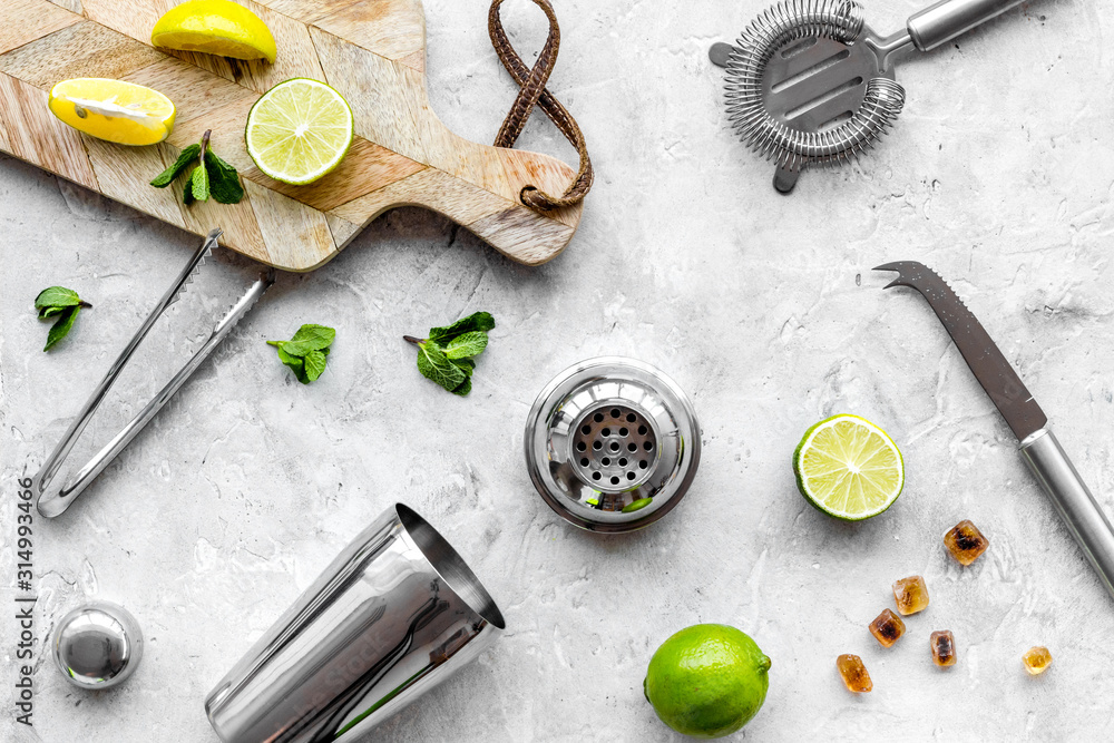 Bar background. Tools and ingredients for making cocktails. Shaker, lime on cutting board on grey ba