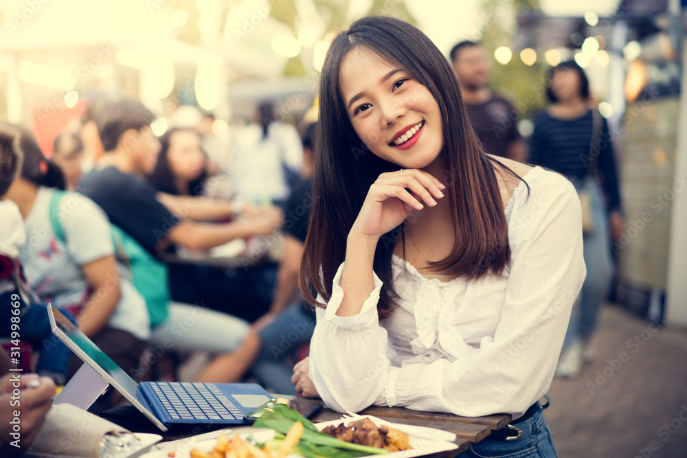 亚洲女人在吃街头食品，她在公司工作