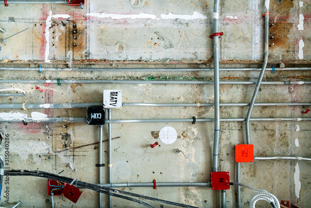 Electrical conduits system and metal pipeline installed on building ceiling Bare skin ceiling electr