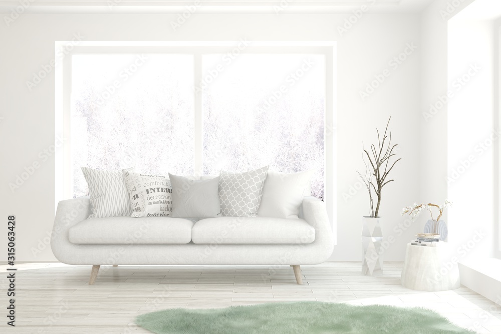 Stylish room in white color with sofa and winter landscape in window. Scandinavian interior design. 