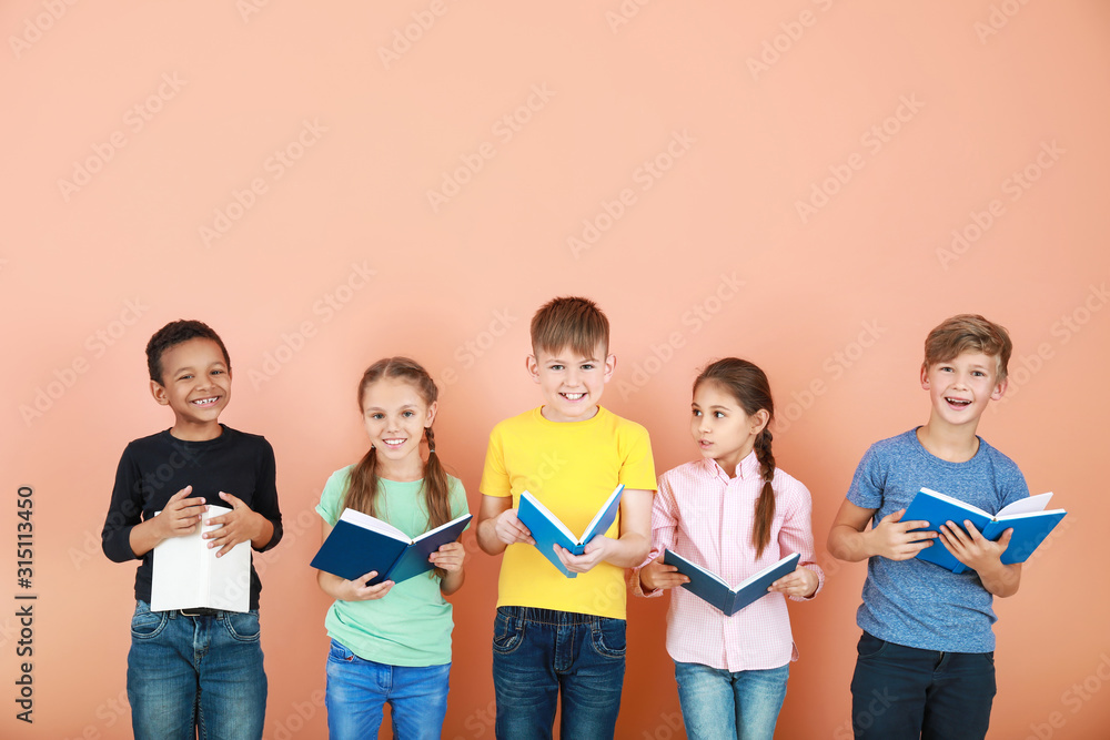 Cute little children reading books on color background