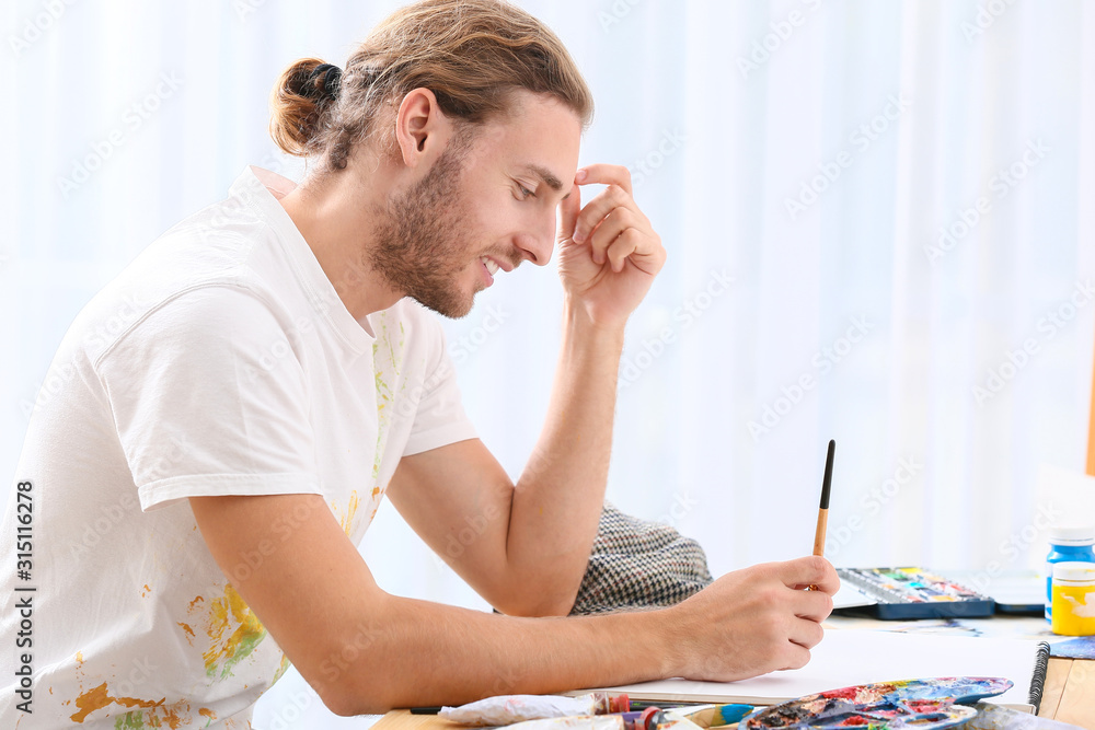 Young male artist working in studio