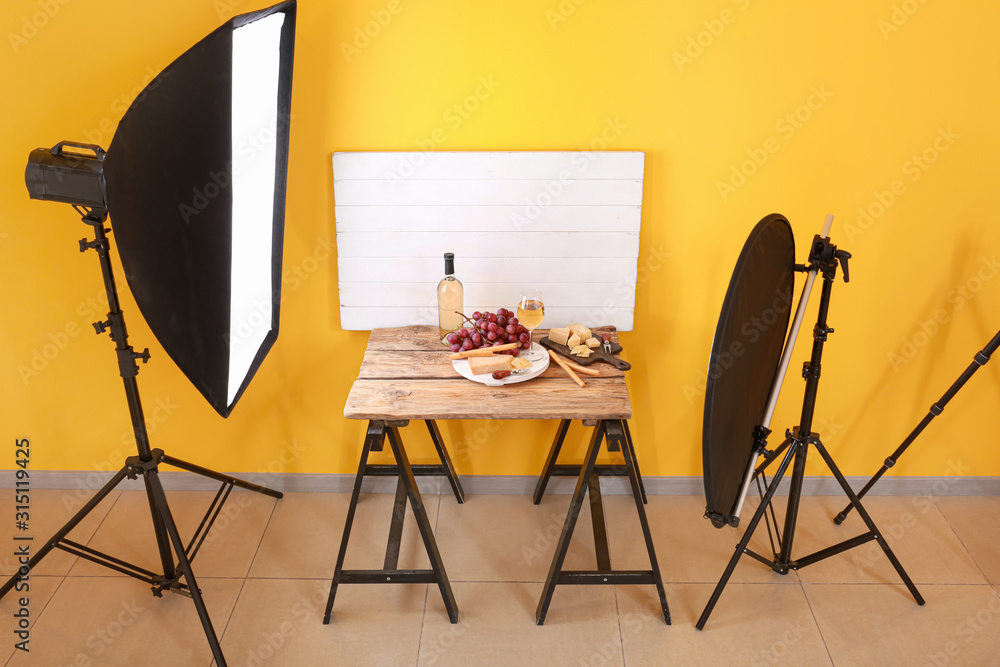 Cheese with wine and grapes on table in professional photo studio