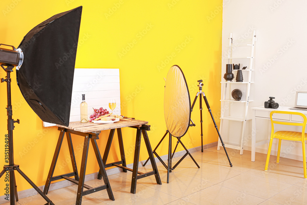 Interior of modern photo studio with professional equipment and food on table