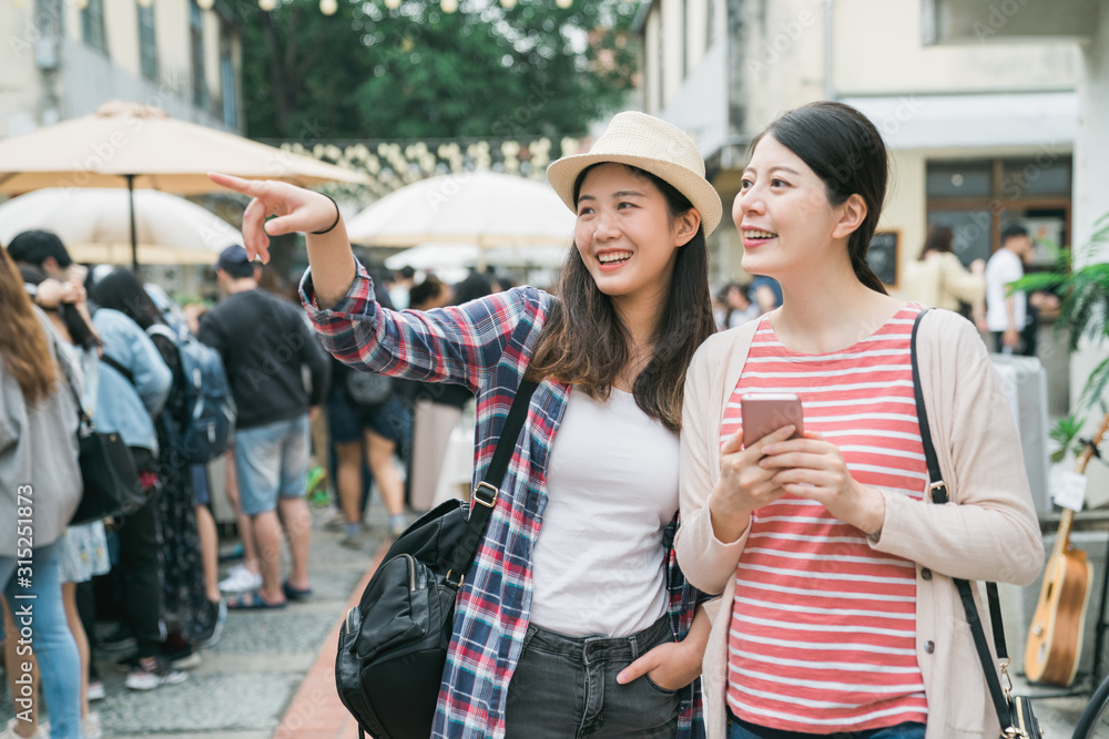 亚洲女孩朋友在城市夏季户外农贸市场。两个年轻的女旅行者拿着c