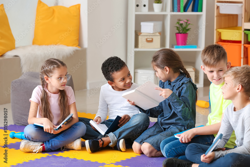 Cute little children reading books indoors