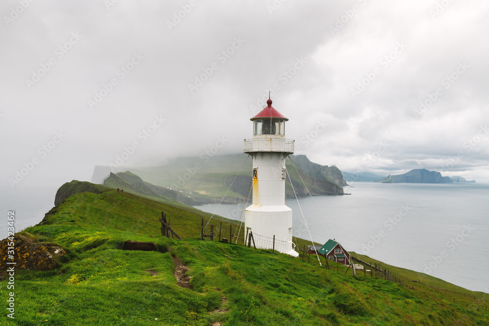 丹麦法罗群岛Mykines岛上旧灯塔的雾景。风景摄影