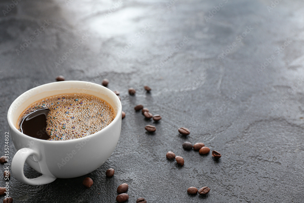 Cup of hot coffee on grey background