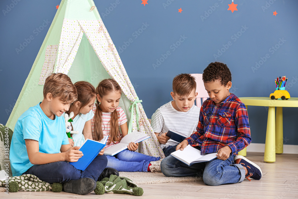 Cute little children reading books indoors