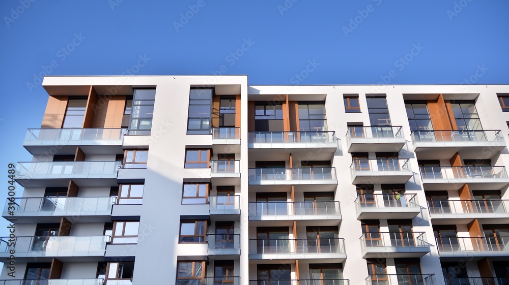 Modern multi story building being lit by the setting sun at afternoon. New apartment house residenti