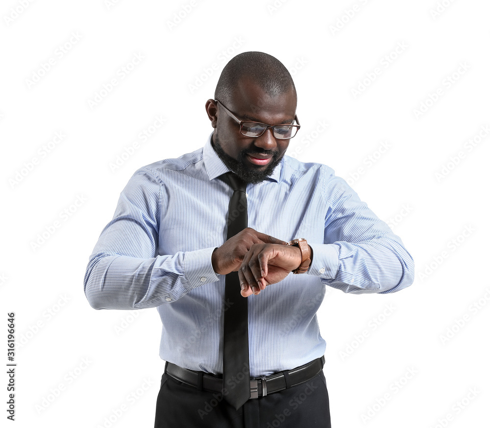 Portrait of African-American businessman looking at his watch on white background