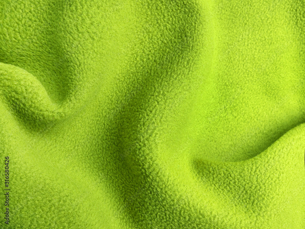 Crumpled warm green polar fleece fabric closeup