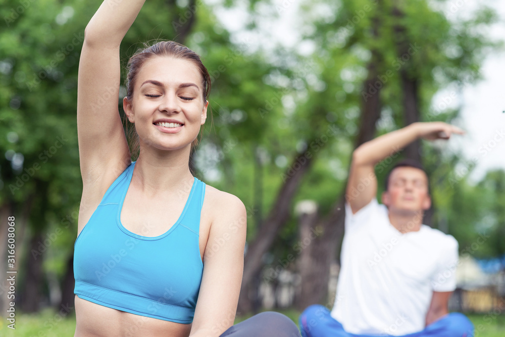 Young couple doing yoga in park together