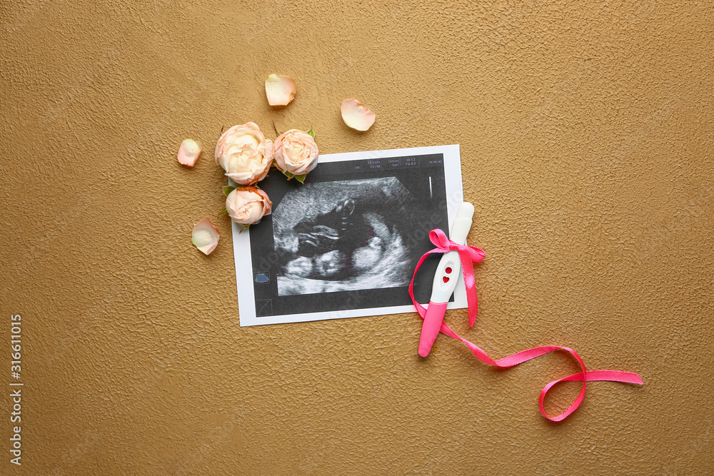 Pregnancy test, sonogram image and flowers on color background