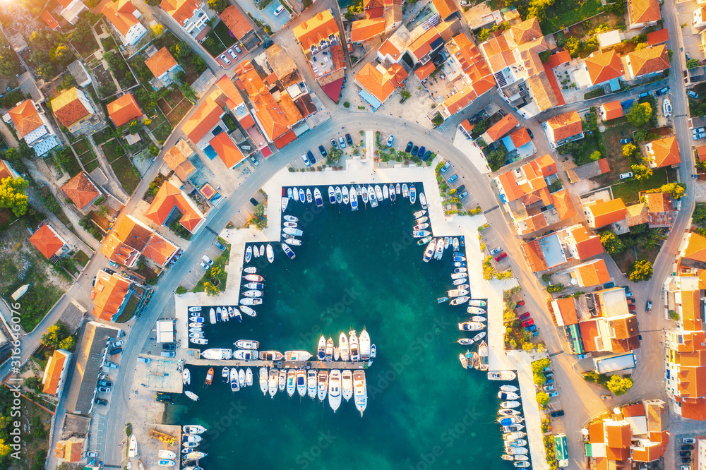 Aerial view of boats and yachts in port in old city at sunset. Summer landscape with houses with ora