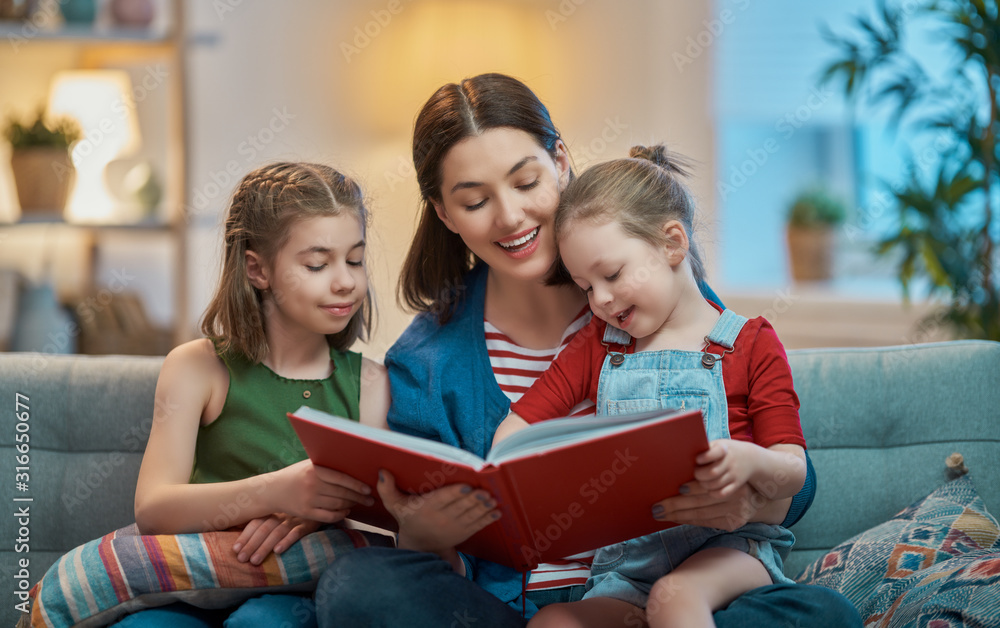 mother reading a book to daughters