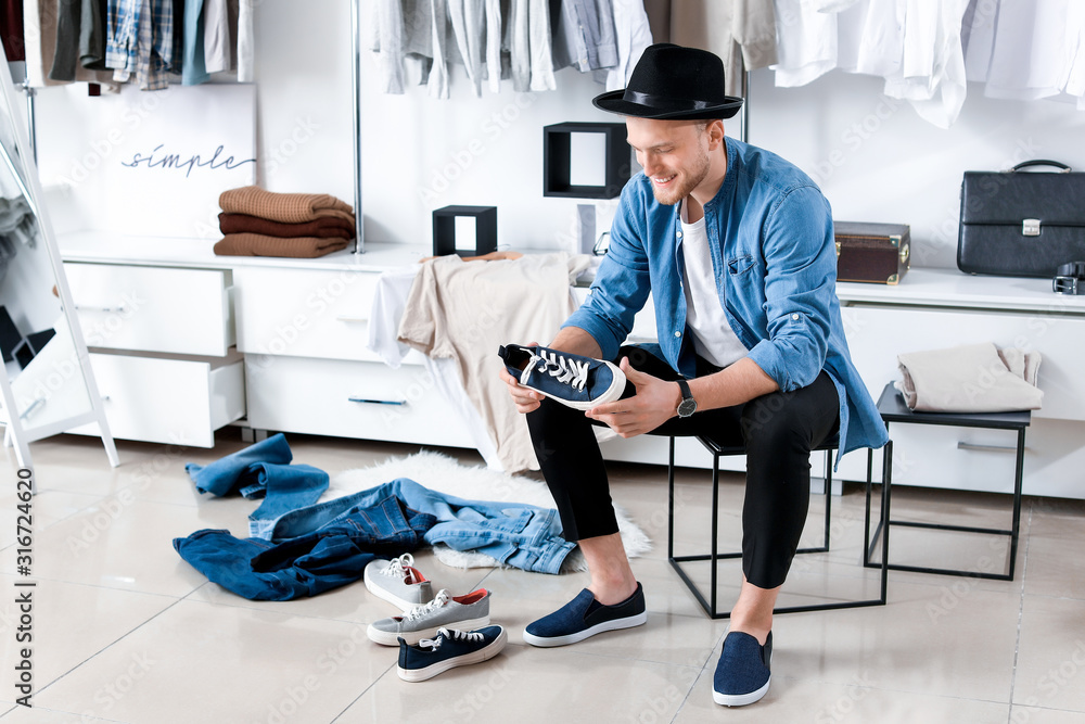 Handsome man choosing shoes in dressing room