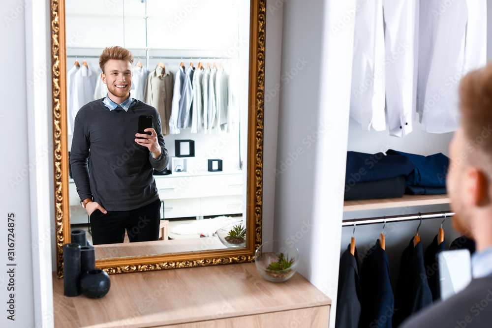 Stylish young man taking selfie in dressing room