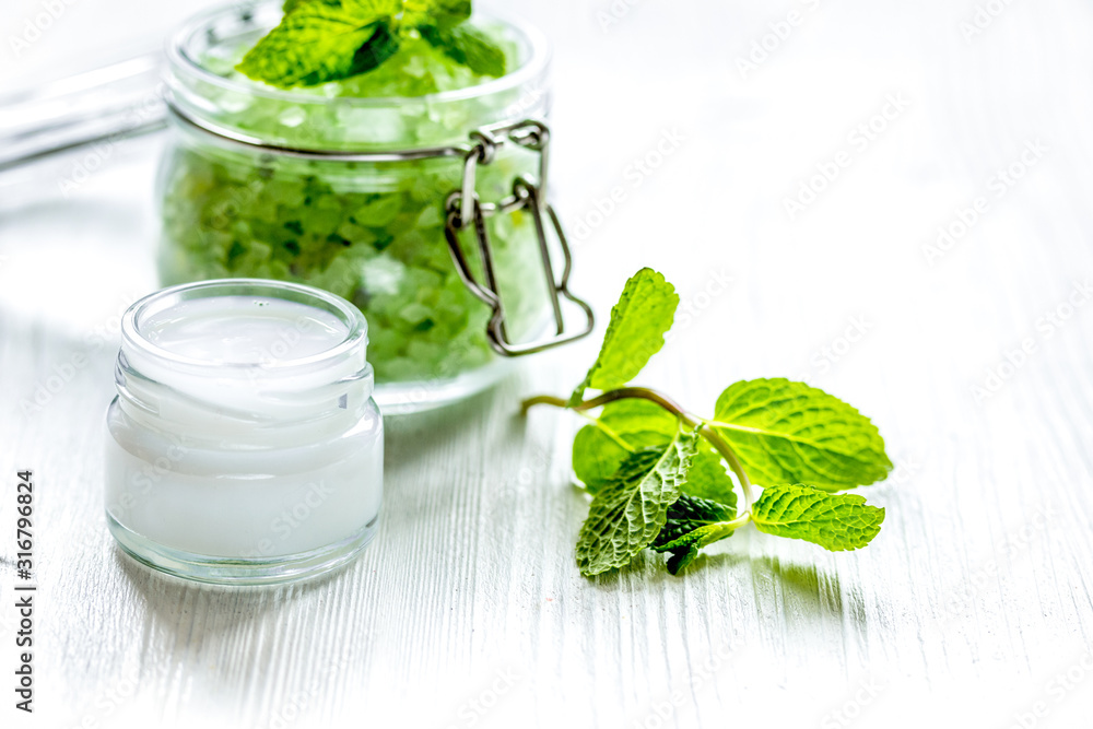 organic cosmetics with herbal extracts of mint on wooden background