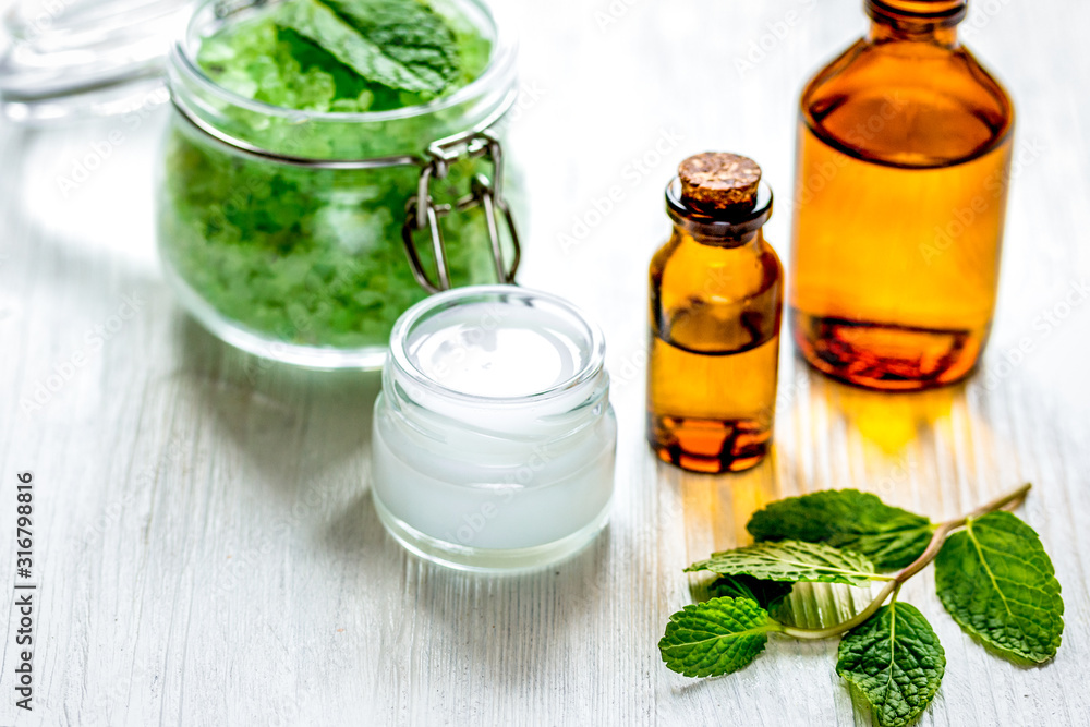 organic cosmetics with herbal extracts of mint on wooden background