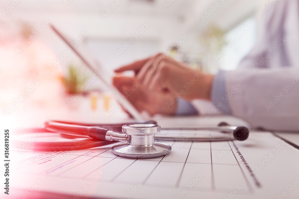 The doctor working with laptop on blurred background