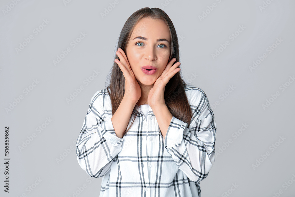 Portrait of emotional woman on grey background