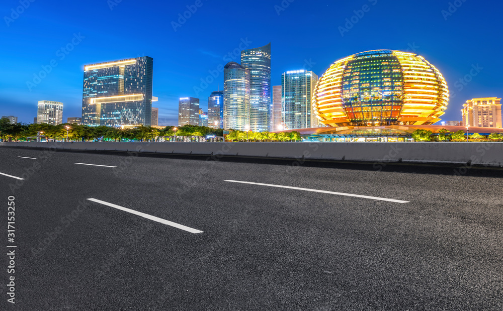 柏油路面的天际线和现代建筑景观的夜景