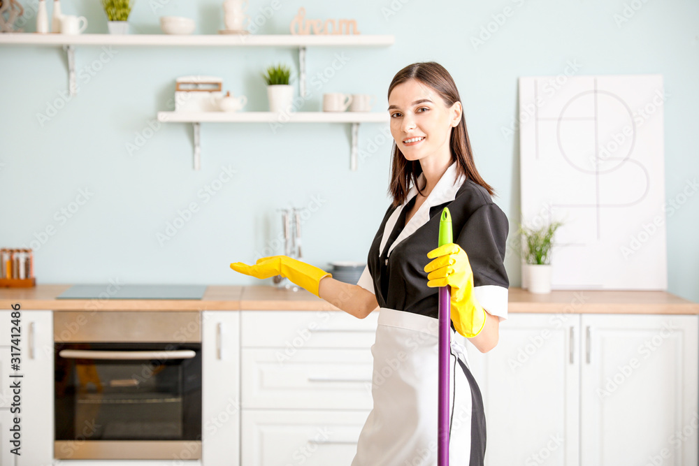 Portrait of beautiful young chambermaid in kitchen