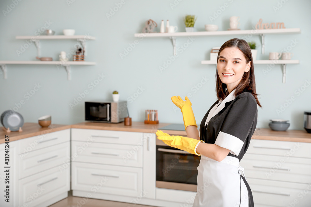 Portrait of beautiful young chambermaid in kitchen