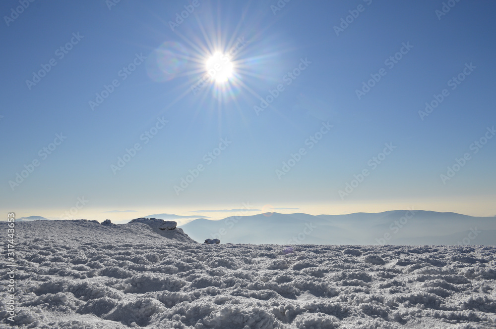 Winter Carpathian mountains on a bright sunny day. Winter snow covered mountain peaks