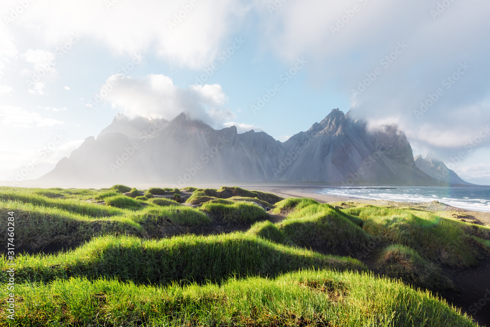 著名的Stokksnes山脉附近有美丽的风景，有黑色的沙丘和长满草的凸起