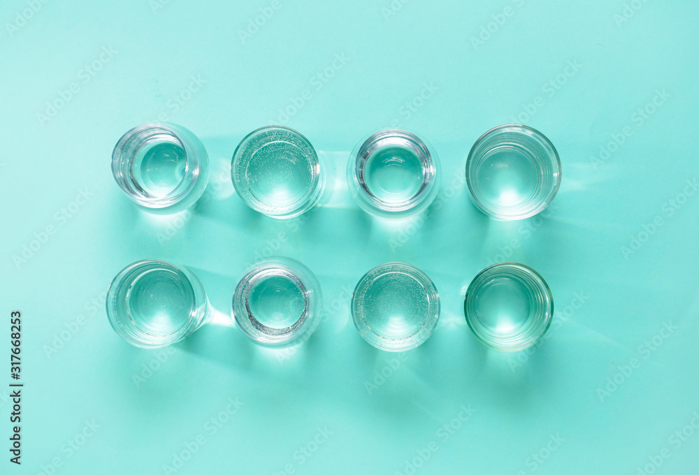 Glasses of clean water on color background