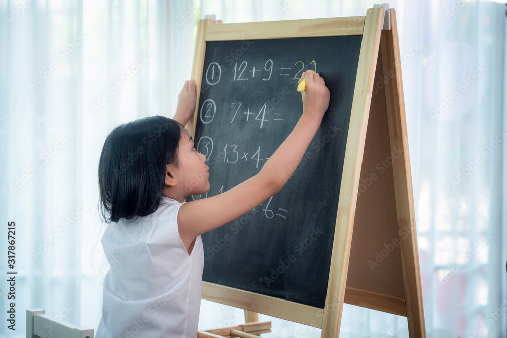 亚洲女孩在回到学校之前在篮板上写字和做家务